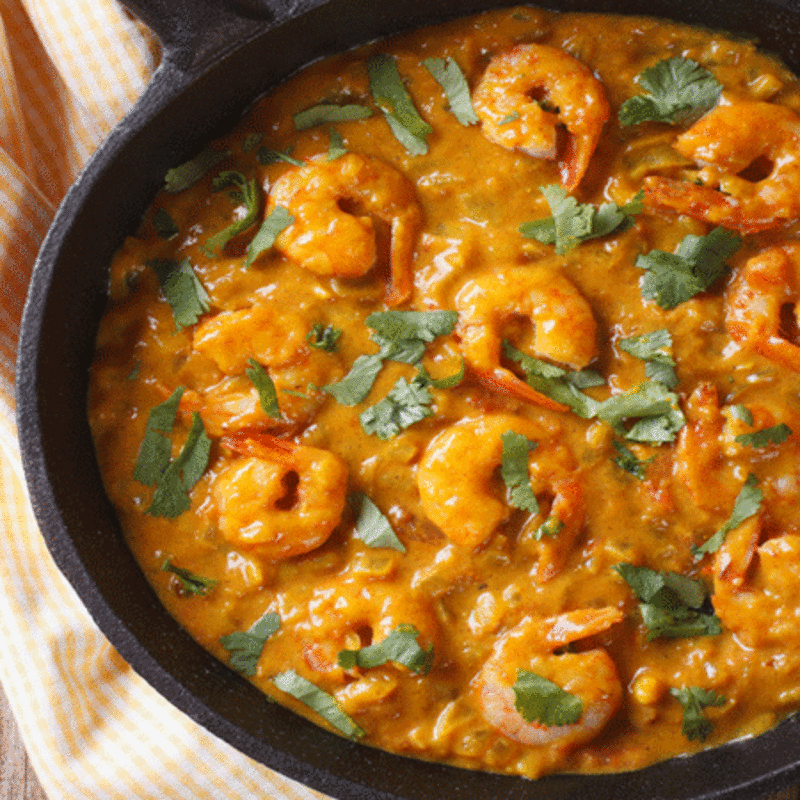 Close-up of succulent prawns in creamy coconut milk sauce 